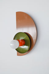 Contemporary geometric light fixture with stacked shapes in a warm fall-inspired palette of fudge brown, olive green, and flame orange, perfect for eclectic or midcentury interiors.