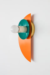 This striking Kin Sconce pairs saturated orange with a rich mermaid green and a grounding cream socket, forming a confident triadic palette. The glossy finish and clean shapes make it a perfect fit for color-curious homes with influences ranging from Memphis design to mid-century modern. Ideal for use in a hallway, powder room, or anywhere a jolt of color and light is welcome.