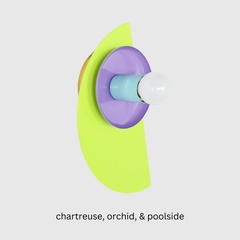 Colorful Kin Sconce in bold chartreuse, vibrant orchid purple, and poolside blue. This geometric wall light blends Memphis design flair with Bauhaus-inspired structure—ideal for playful kids’ rooms, creative studios, or eclectic modern interiors.
