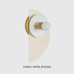 Bauhaus-inspired Kin Sconce featuring a powder-coated cream base, peach reflector dish, and brass socket. A sculptural, geometric wall light that adds soft warmth and modern edge to bathrooms, hallways, or playful minimalist interiors.