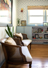 Living room design mixes pastel blue with warm neutrals like tan, terra cotta, and wood tones.  The terra cotta and brass wall sconce is made in New Orleans by Sazerac Stitches.