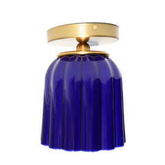 Marcella flushmount light fixture in glazed cobalt blue ceramic with a fluted Art Deco-inspired shape and warm brass canopy. A sculptural, handmade ceiling light perfect for hallways, powder rooms, or color-drenched interiors. Elegant blue ceramic flush mount with vintage charm.