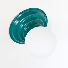 Mermaid Green or Emerald Green flushmount ceiling light or wall sconce with a frosted white globe. Stepping back into a bygone era with a touch of modern minimalism, the Abeille Sconce or Flushmount is an artistic blend of form and function. This wall sconce doubles as a flushmount ceiling light, making it a versatile lighting solution for any space. Designed akin to a beehive, its charismatic shape is complemented by curated color options that add a playful element to its retro appeal.