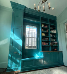 Customer-installed Milne Knobs in solid brass shown on vibrant teal painted cabinetry with oak countertop. The three-piece curvy brass cabinet knobs add a bold yet refined detail to the custom cabinetry, blending classic craftsmanship with a modern pop of color. This stylish hardware choice elevates the eclectic, maximalist look of the space while offering functionality and visual interest. Ideal for kitchens, built-ins, or statement storage units, the Milne Knob is available in all brass or a mixed brass a