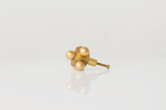 Small Brass Knob with Mid-Century Modern Influence – A minimalist brass cabinet knob with a geometric form, featuring four spheres and a central cube.