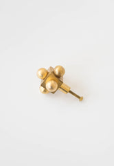 Small Brass Knob with Mid-Century Modern Influence – A minimalist brass cabinet knob with a geometric form, featuring four spheres and a central cube.