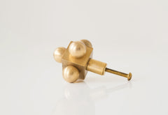 Small Brass Knob with Mid-Century Modern Influence – A minimalist brass cabinet knob with a geometric form, featuring four spheres and a central cube.