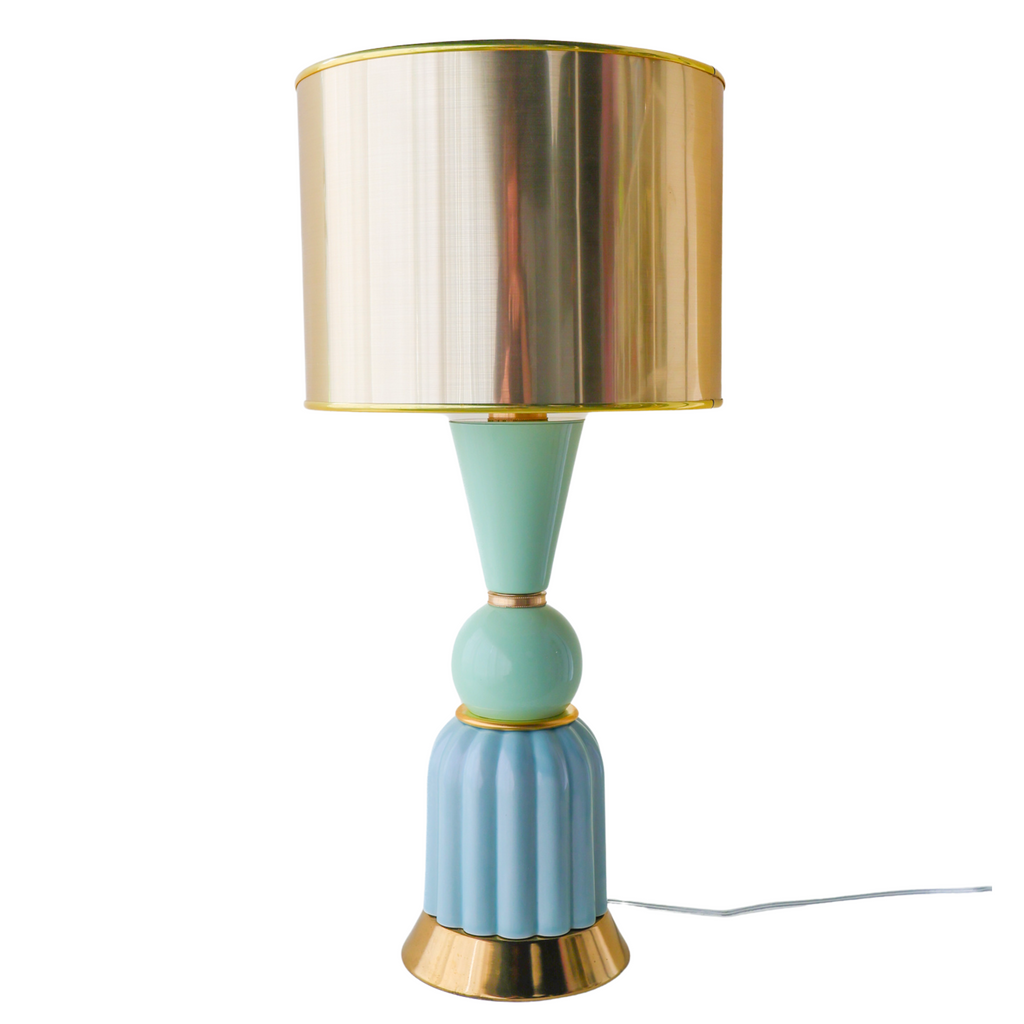 Close-up of a handmade mint green and aqua ceramic table lamp with a fluted aqua base, smooth mint taper detail, and polished gold drum lampshade. Features brushed brass hardware and a sculptural mid-century modern design perfect for living rooms, bedrooms, or stylish desks.