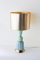 Full view of a mint and aqua ceramic table lamp featuring a ribbed aqua ceramic base, glossy mint green sphere and cone details, and a reflective gold drum lampshade. Elegant brass accents highlight this artisan-made, mid-century inspired lighting fixture.