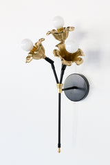 black and brass floral wall sconce.  Each socket includes a large brass flower.  Romantic and unique wall mounted wall sconce with three sockets.  Black and brass finish adds modernity