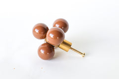 An oversized decorative drawer pull featuring five glossy fudge brown spheres arranged around a solid brass cube. The cube is mounted to a brushed brass stem and screw, designed for installation on cabinets or drawers. The geometric design and mixed materials give it a sculptural, modern look with a midcentury flair. Photographed on a clean white background.