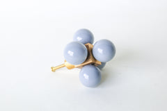 An oversized decorative drawer pull featuring five glossy grey spheres arranged around a solid brass cube. The cube is mounted to a brushed brass stem and screw, designed for installation on cabinets or drawers. The geometric design and mixed materials give it a sculptural, modern look with a midcentury flair. Photographed on a clean white background.