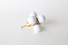 Designer oversized drawer pull in polished brass and white powdercoated 
 spheres, arranged in a geometric cube formation. Shown on a clean surface to highlight its architectural form and elevated craftsmanship, perfect for bold interior design upgrades and luxury cabinetry hardware collections.