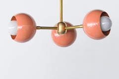 Peach & Brass Mid Century Modern style 3-light flushmount ceiling light fixture.  Features brass hardware with powdercoated glossy peach shades.  Adds color and unique style to any ceiling.  Great ceiling light fixture for low ceilings, kids rooms, bathrooms, peach decor, and more.
