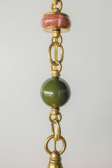 Close-up of the Peach, Olive, & Rose Marble Beaded Pendant Light showing rose marble disc, olive bead, and polished brass chain links.