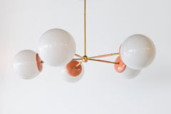 Peach & Brass modern chandelier. Mid Century modern style with oversize white globe shades.