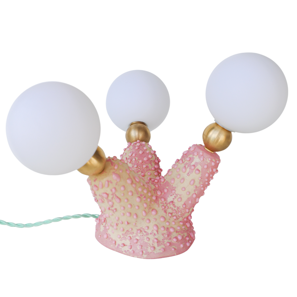 Top-down view of the Pink Polyp Lamp with three branching ceramic arms finished in hand-painted pastel and bubblegum pink glazes, each tipped with a G9 socket and frosted screw-on bulb, glowing softly to provide ambient light—an ideal accent for creative, maximalist interiors and one-of-a-kind decor lovers.