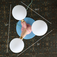 Top-down view of handmade pink ceramic creature lamp with three branching arms and frosted glass globes, showing dimensions of 17", 15", and 14.5" across on a vintage rug background
One-of-a-kind sculptural ceramic table lamp with a whimsical sea-creature-inspired form, hand-built from stoneware and finished in bumpy bubblegum pink glaze. Features three brass-tipped arms with frosted G9 glass globes, mint green cord, and playful pastel blue base—shown with measurements for size reference. Ideal for offbeat,