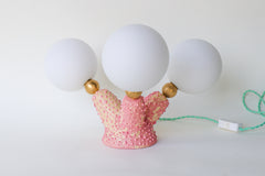 One-of-a-kind handcrafted pink stoneware table lamp with three round white glass globe bulbs, raw brass accents, and pastel mint green cord — artistic statement lighting for offbeat modern decor