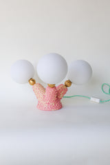 One-of-a-kind handcrafted pink stoneware table lamp with three round white glass globe bulbs, raw brass accents, and pastel mint green cord — artistic statement lighting for offbeat modern decor