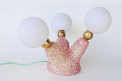 Top-down view of the Pink Polyp Lamp with three branching ceramic arms finished in hand-painted pastel and bubblegum pink glazes, each tipped with a G9 socket and frosted screw-on bulb, glowing softly to provide ambient light—an ideal accent for creative, maximalist interiors and one-of-a-kind decor lovers.