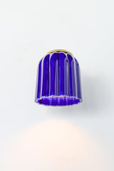 Marcella ceramic wall sconce in high-gloss glazed cobalt blue with brushed brass hardware, featuring a fluted silhouette and jewel-toned finish. This bold statement light blends classic craftsmanship with modern maximalist style—ideal for traditional powder rooms, eclectic interiors, or coastal-inspired spaces seeking a vibrant pop of color.