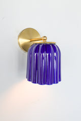 Marcella ceramic wall sconce in high-gloss glazed cobalt blue with brushed brass hardware, featuring a fluted silhouette and jewel-toned finish. This bold statement light blends classic craftsmanship with modern maximalist style—ideal for traditional powder rooms, eclectic interiors, or coastal-inspired spaces seeking a vibrant pop of color.