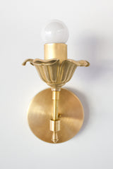 Brass floral wall sconce with cast brass detailing.  Modern take on traditional style brass light fixtures that retails old-world European charm with the finial and brass flower