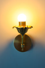 Brass floral wall sconce with cast brass detailing.  Modern take on traditional style brass light fixtures that retails old-world European charm with the finial and brass flower. Octavia wall sconce made by Sazerac Stitches in New Orleans