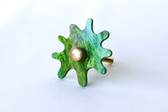 Splat drawer pull in pearl grass acrylic with a brass detail installed on a colorful dresser drawer, demonstrating its easy installation and ability to add a unique touch.