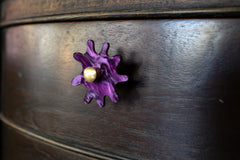 Wood nightstand with purple splat knobs attached
