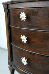 Splat drawer pull in white pearl acrylic with a brass detail installed on a colorful dresser drawer, demonstrating its easy installation and ability to add a unique touch.