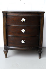 Splat drawer pull in white pearl acrylic with a brass detail installed on a colorful dresser drawer, demonstrating its easy installation and ability to add a unique touch.