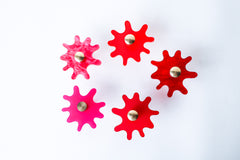 Multiple Splat drawer pulls in various finishes like pink and red arranged on a white background, showcasing their versatility and playful character.