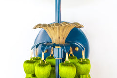 Close-up of the Tropical Tasseled Wall Sconce showing the sculpted antique brass flower detail, glossy lagoon blue backplate, and vibrant chartreuse green silk tassels. Perfect for eclectic, midcentury modern, and tropical-inspired interiors, this playful designer wall light adds texture, color, and artistic charm.