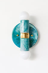 Close-up view of the Teal and Grey Marbled Thalia Sconce, a modern double-bulb wall light featuring hand-marbled teal and grey enamel with solid brass accents. This sculptural lighting fixture blends artistic flair with function, making it a standout in bathrooms, powder rooms, or hallways.