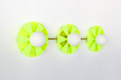 Neon Green Triple Circus Sconce: Steal the show with a touch of modern luxury! The Neon Green Triple Circus Sconce features three intricately etched green acrylic discs, drawing inspiration from the rich hues of Murano glass. Each disc casts mesmerizing light and shadow patterns, making this statement piece a true conversation starter.