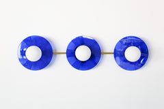 Bright Blue Triple Circus Sconce: Bold and dazzling, the Bright Blue Triple Circus Sconce captures the essence of Murano glass with its vibrant blue acrylic disc. Each intricately etched disc casts mesmerizing light and shadow patterns, transforming your walls into a captivating display.