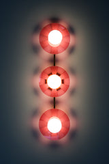 Infuse your space with playful energy with the Fuchsia Fever Triple Circus Sconce. This pink light fixture features three intricately etched acrylic discs, each casting a captivating dance of light and shadow on your walls.