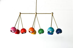 Brightly colored rainbow chandelier fixture with candy colored shades, brass hardware, and a long linear shape.  Beautiful and colorful statement lighting. Bright Rainbow Turmalina Chandelier by Sazerac Stitches - front view