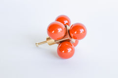 Bright Flame Orange Ball-Cube Knob – A bold red and brass cabinet knob with a geometric design, resting on a white surface.