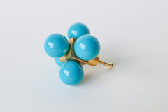 Teal blue Ball-Cube Knob – A vibrant turquoise and brass knob with a modern, playful design, set against a white background.