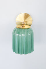 Glazed jade green ceramic Marcella sconce with fluted scalloped shade and brushed brass hardware; a handcrafted wall light ideal for bathrooms, powder rooms, or hallways in traditional, Southern, coastal, cottagecore, New England prep, grandmillennial, vintage-inspired, Art Deco, eclectic, or transitional interiors.