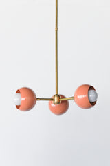 Peach & brass mid century modern style small chandelier with brass hardware and peach powdercoated glossy shade.  Adds a touch of color and style to any small space like a bedroom or bathroom.