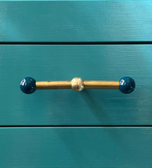 Double Wide Gumball drawer pull in lagoon blue and raw brass shown on vibrant teal cabinetry. This playful, oversized pull features hand-painted gumball ends and a warm brass rod, blending sculptural design with bold color. Ideal for eclectic, modern, or maximalist interiors, the pull adds a striking visual pop to kitchen drawers, dressers, or custom millwork. A handcrafted hardware option that adds both personality and function to colorful, design-forward spaces.