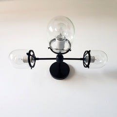 Clear glass and matte black three light bathroom wall sconce or vanity lighting for modern bathroom renovations