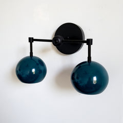 mid century modern inspired light with dark teal shades and matte black hardware.  The Double Loa sconce is a two light sconce that comes in fun colored shades and three metal options.