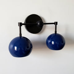 mid century modern inspired two light wall light with globe shades in navy and matte black.  Great for modern bathroom renovations, kids bathrooms, etc.