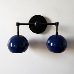 mid century modern inspired two light wall light with globe shades in navy and matte black.  Great for modern bathroom renovations, kids bathrooms, etc.