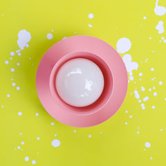 Pastel pink sconce or ceiling light fixture with a mid century modern style front view